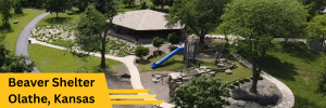 Aerial view of a park area with a prominent yellow banner in the lower left corner that reads "Beaver Shelter Olathe, Kansas". The park is lush and green, with mature trees and a playground for children.